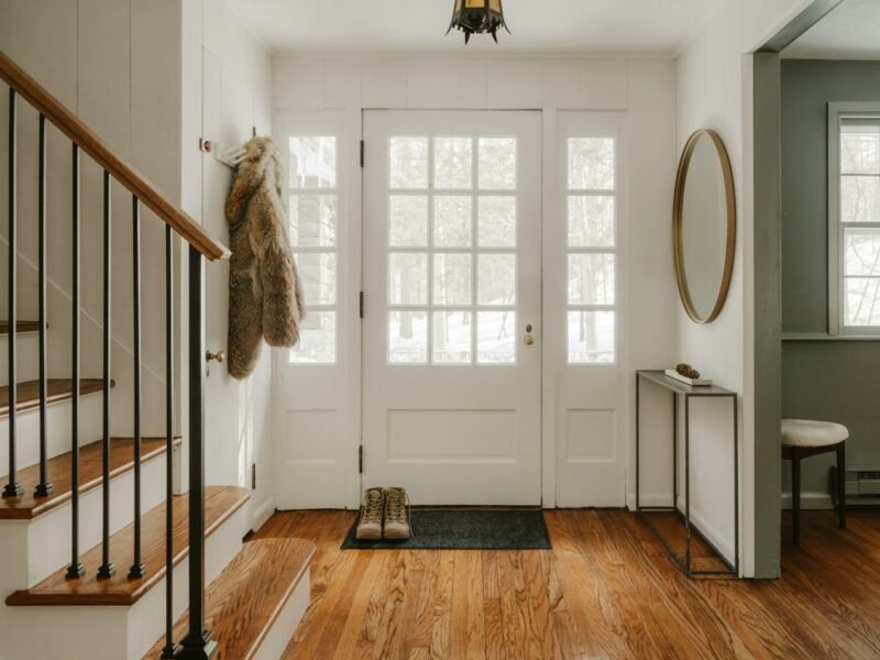 Warm home entryway with staircase and front door