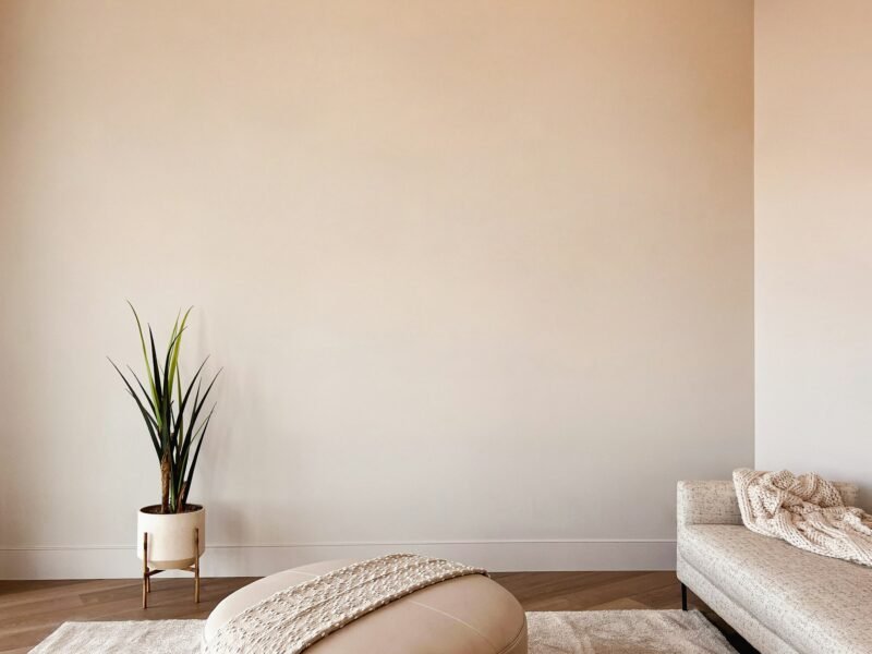 A living room furnished in creamy neutrals with a vase of flowers